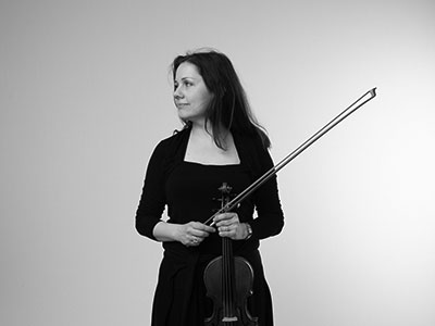 Naomi Mitchell holding a violin and looking to the right