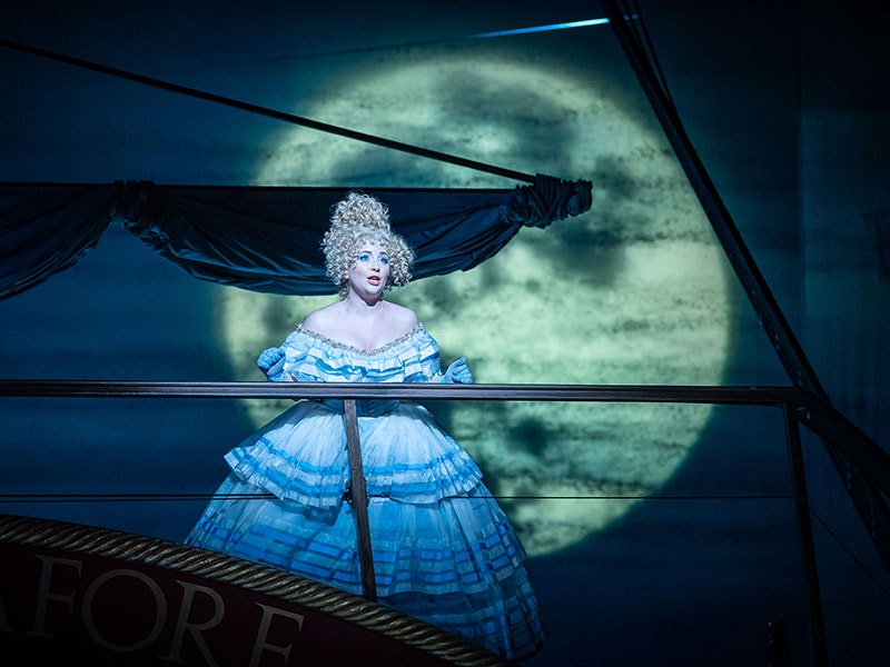 Women in a blue dress singing on the London Coliseum stage