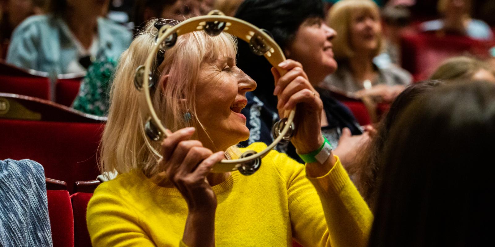 Lady with tambourine in workshop in London Coliseum auditorium