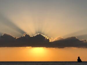 A photograph of the sun shining through the clouds