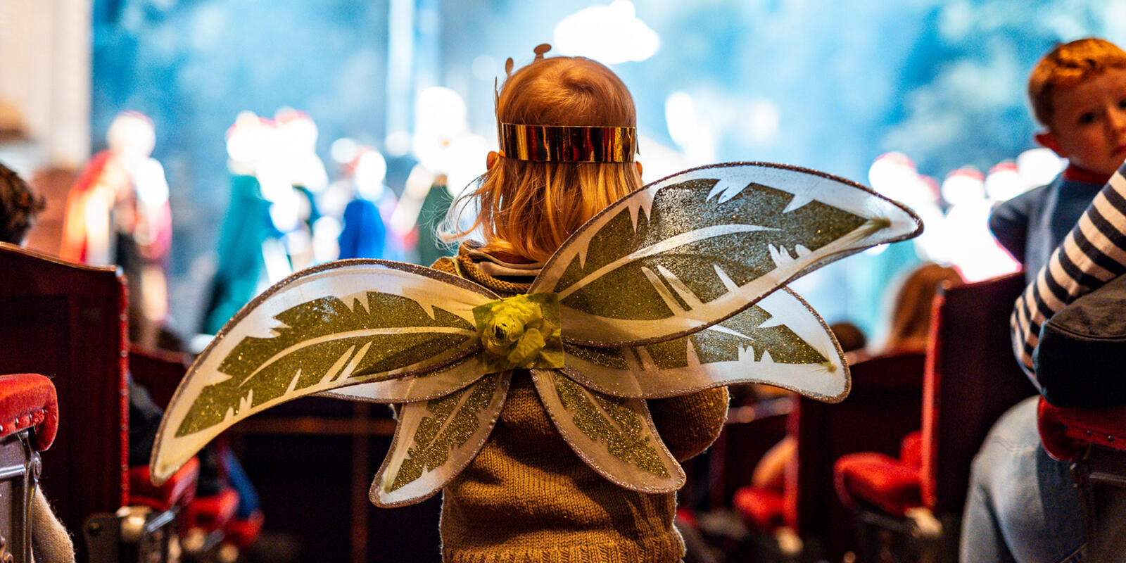Back view of a young child dressed as a fairy in the auditorium watching the stage of the London Coliseum during the Relaxed performance of ENO's Iolanthe---Wednesday 25 October 2023 © Lloyd Winters
