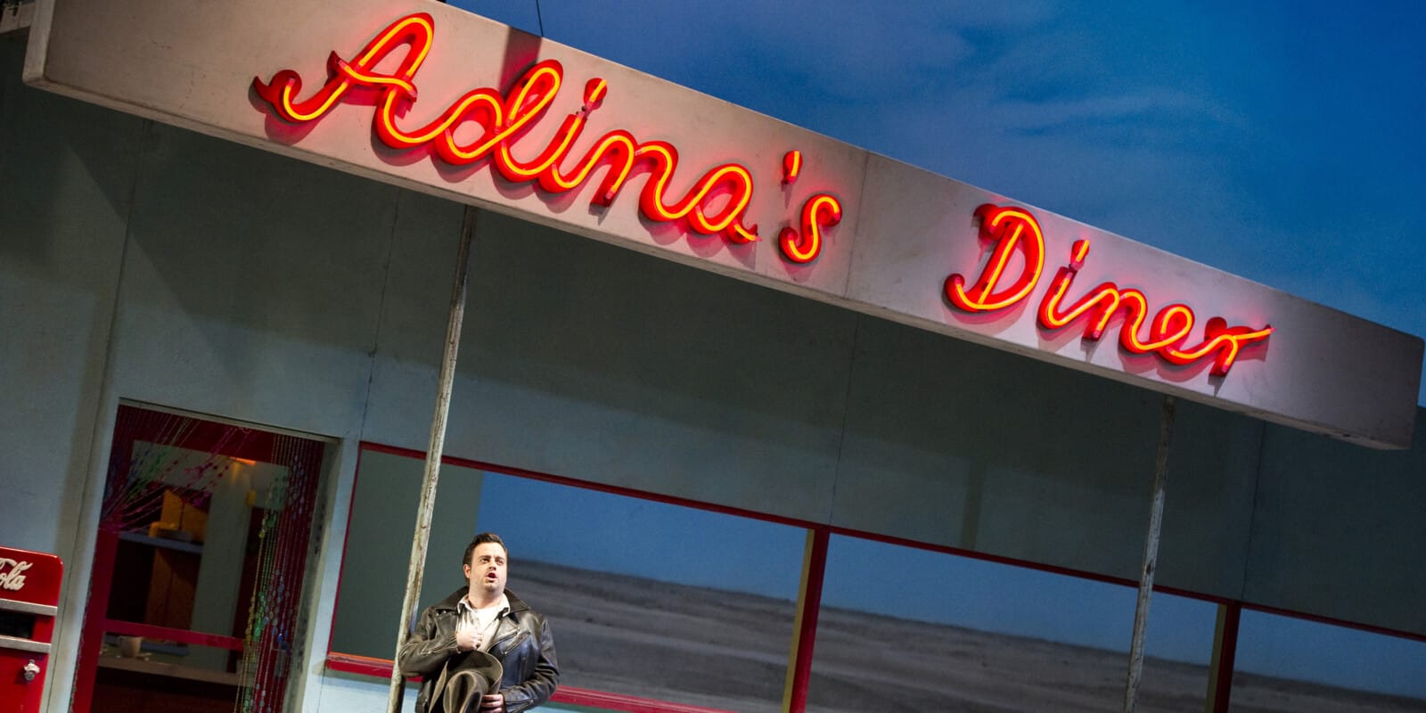 Adina's Diner with man standing under sign