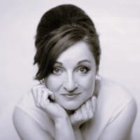 Black and white image of Ailish with head resting in hands